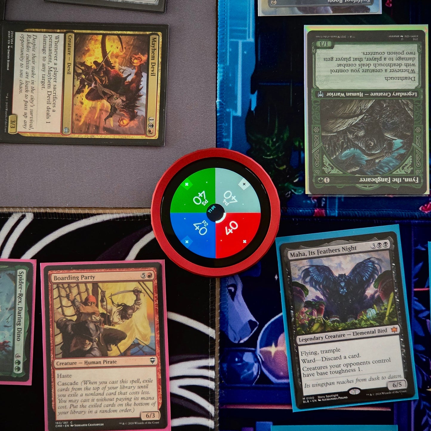 Collection of trading cards on a surface with a colorful TCG Digital Life Counter in the center.