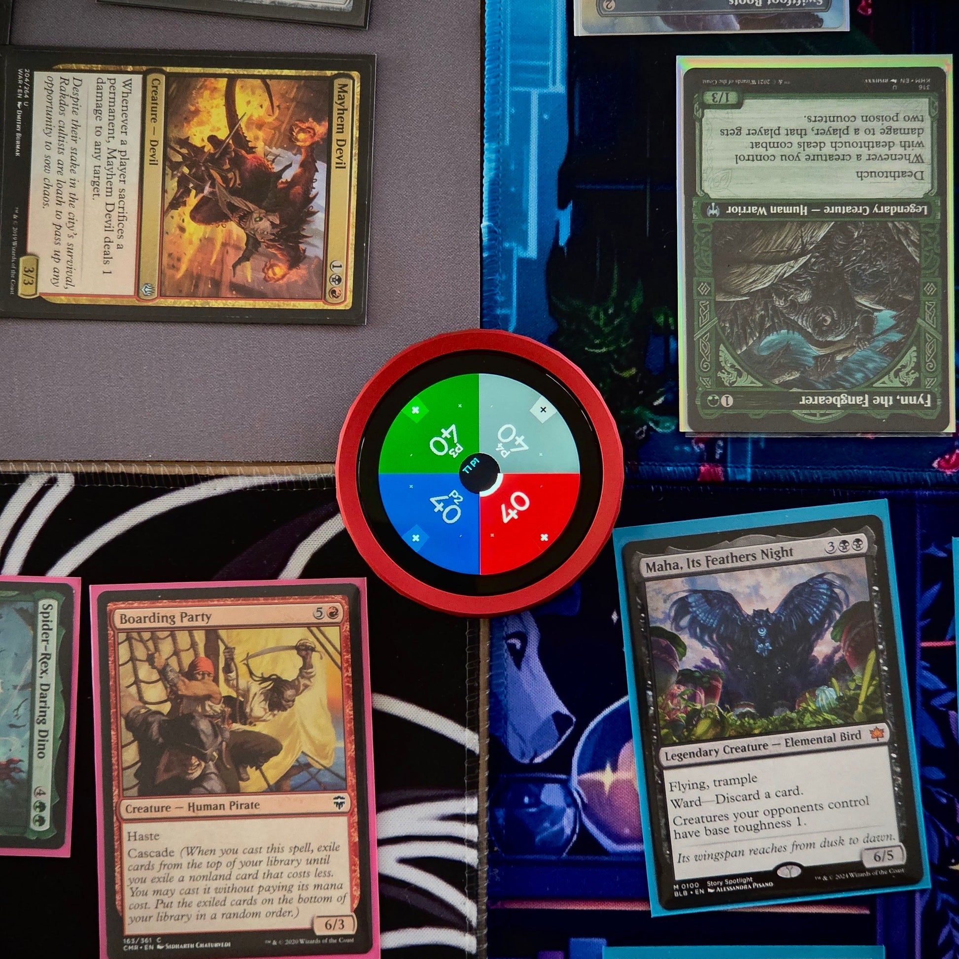 Collection of trading cards on a surface with a colorful TCG Digital Life Counter in the center.