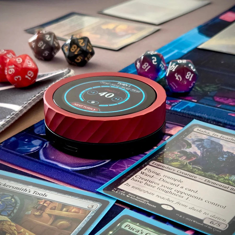 A red Soul Dial on a play mat beside red and purple d20s